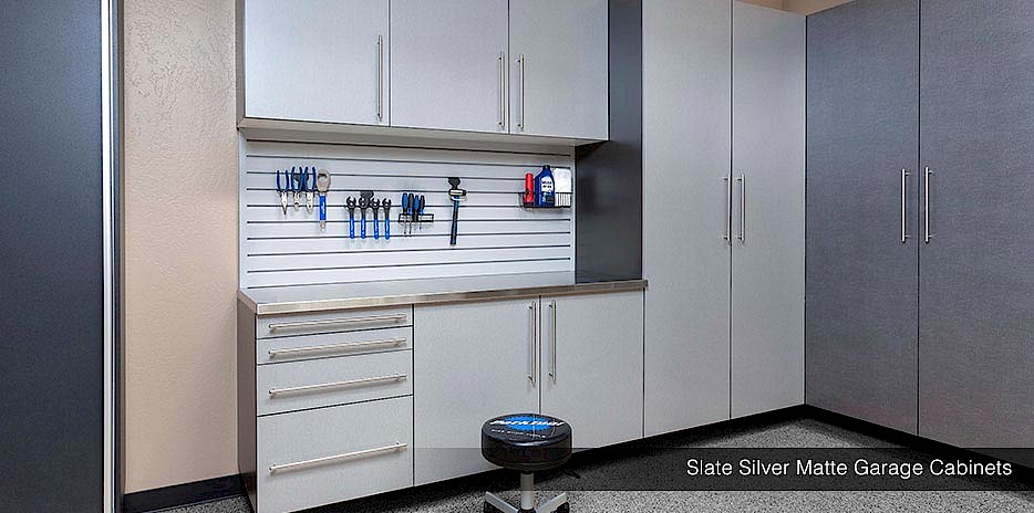 Custom garage cabinets in silver matte paired with a slat wall system and custom workbench, make for a polished and complete garage.